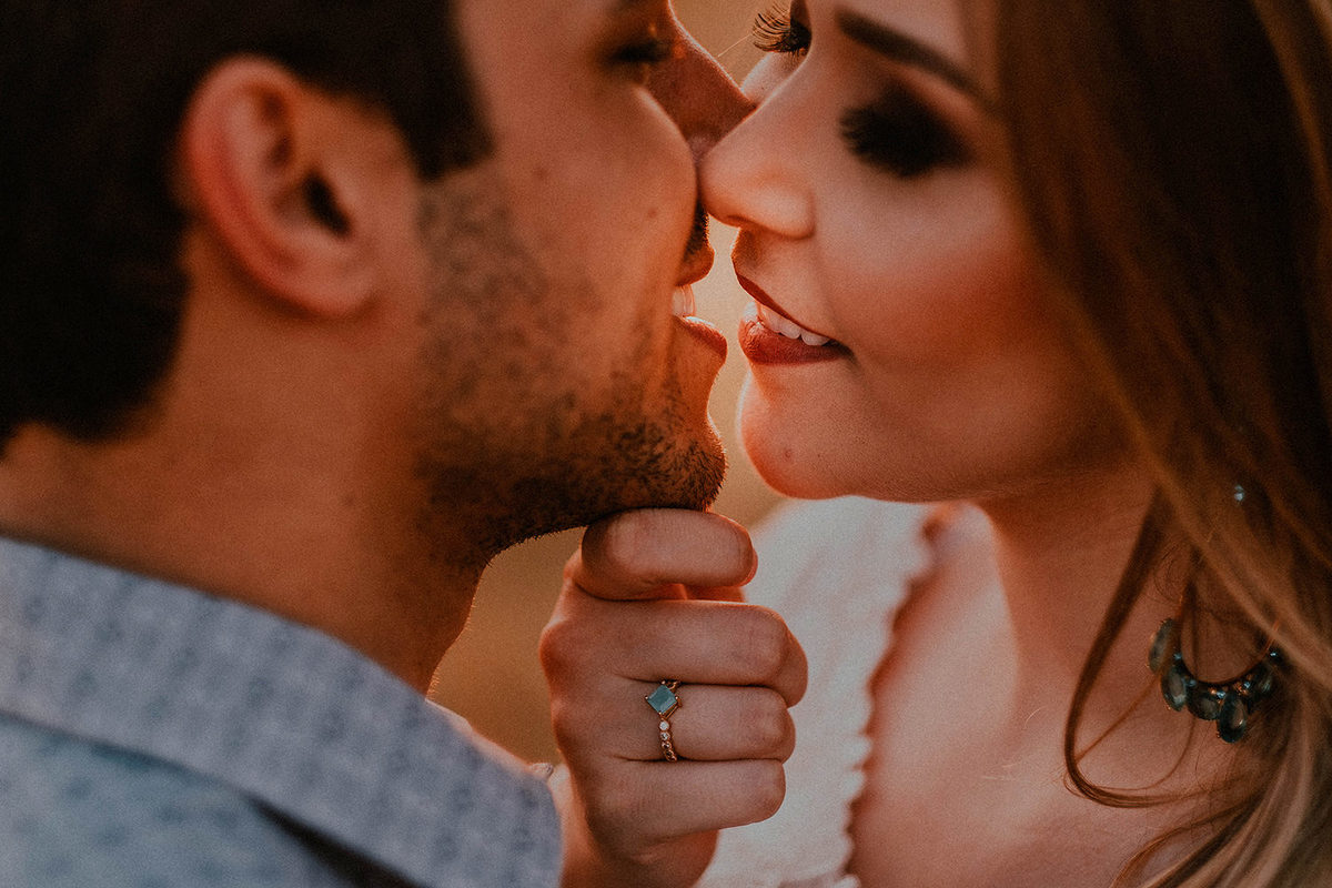 Foto de casal com clouse no beijo com a cor dourada do sol