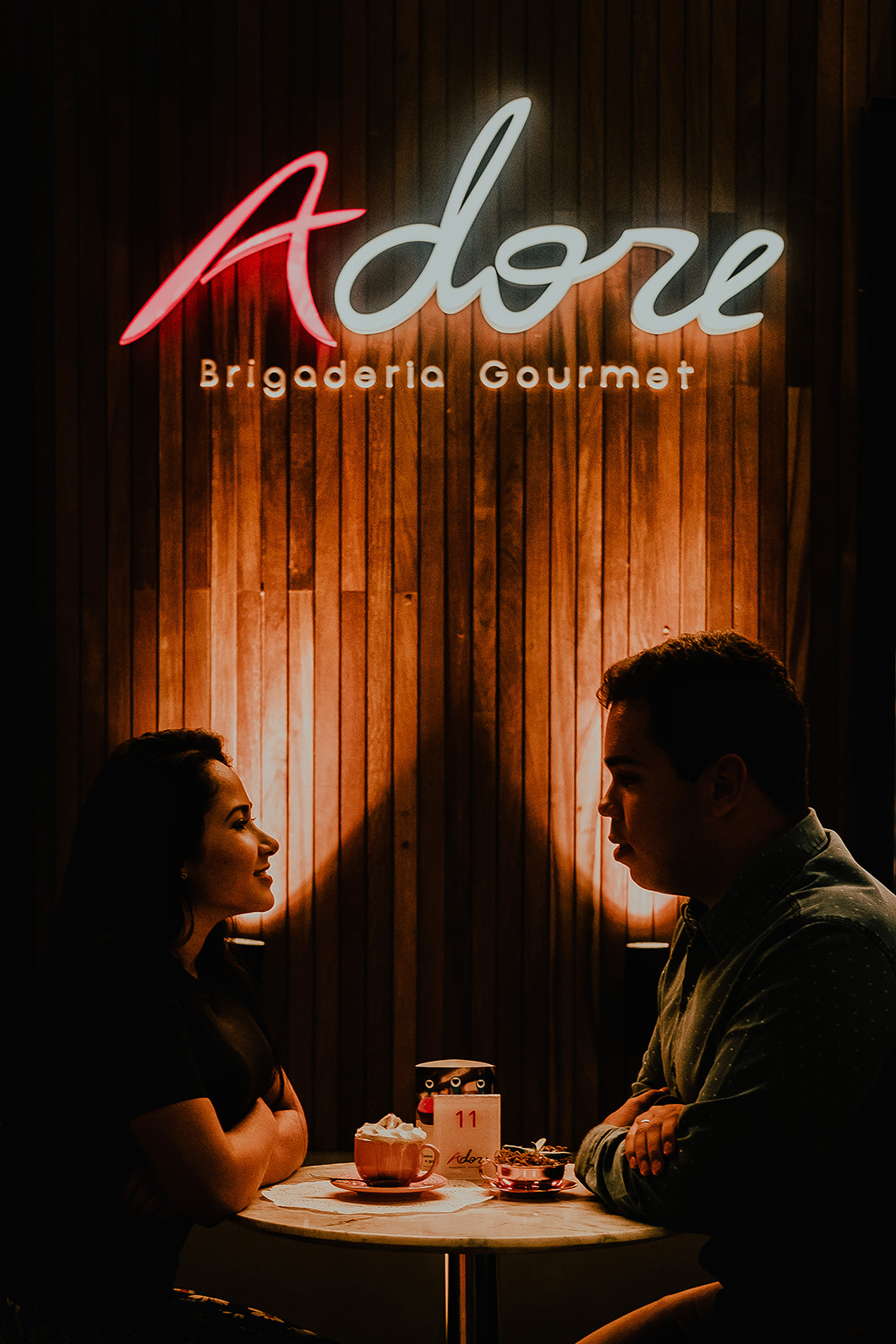 Foto de silhueta para ensaio de casal utilizando luzes de lanchonete 