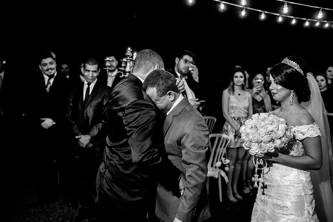 Noivo emocionado ao abraçar o pai da noiva 