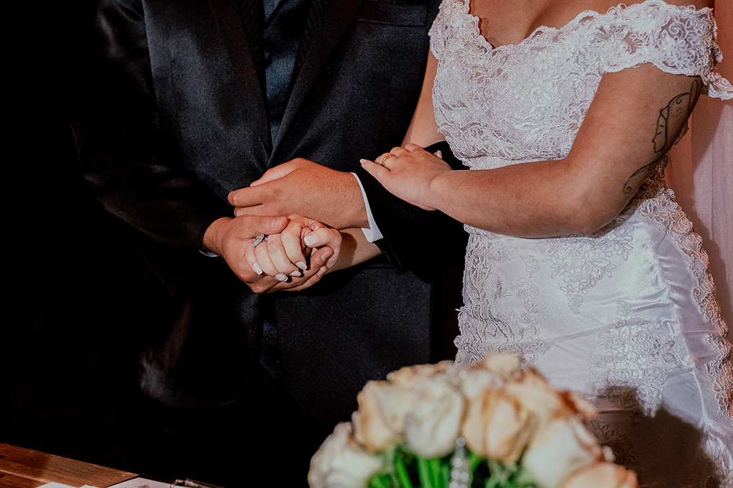 Fotografia de detalhes dos noivos durante a cerimonia de casamento noturno 
