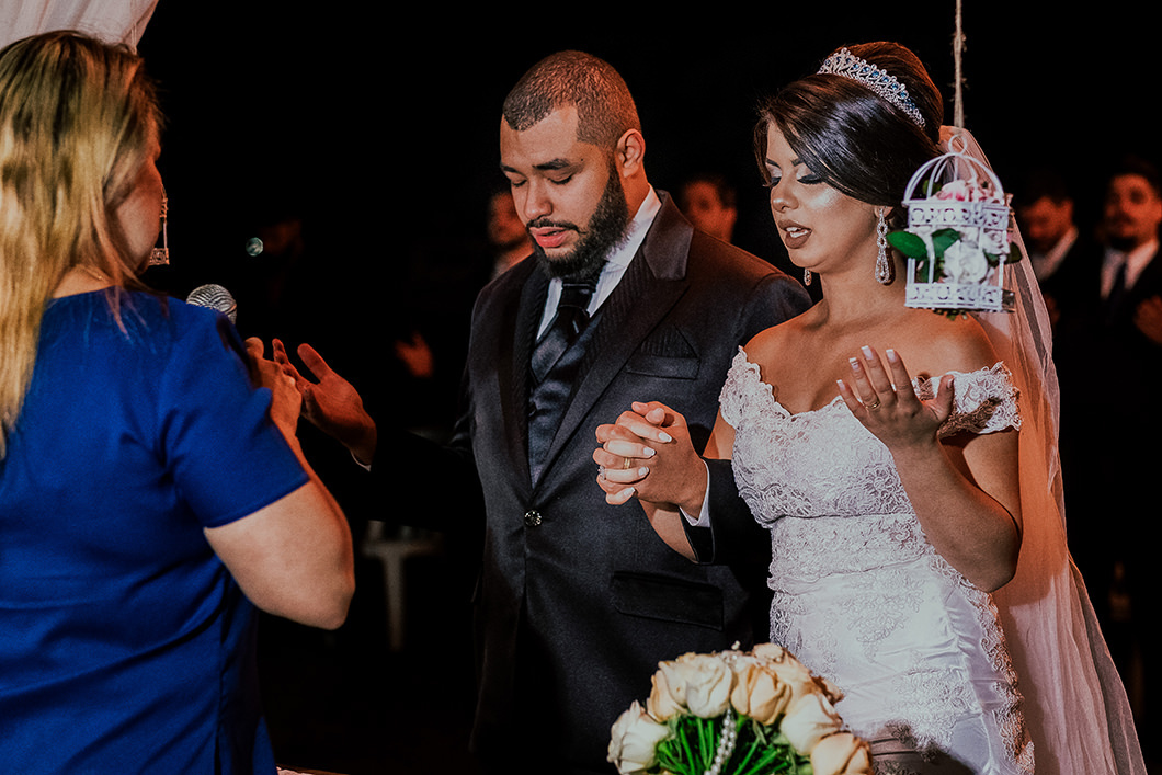 Noivos rezando em fotos de casamento ao céu aberto 