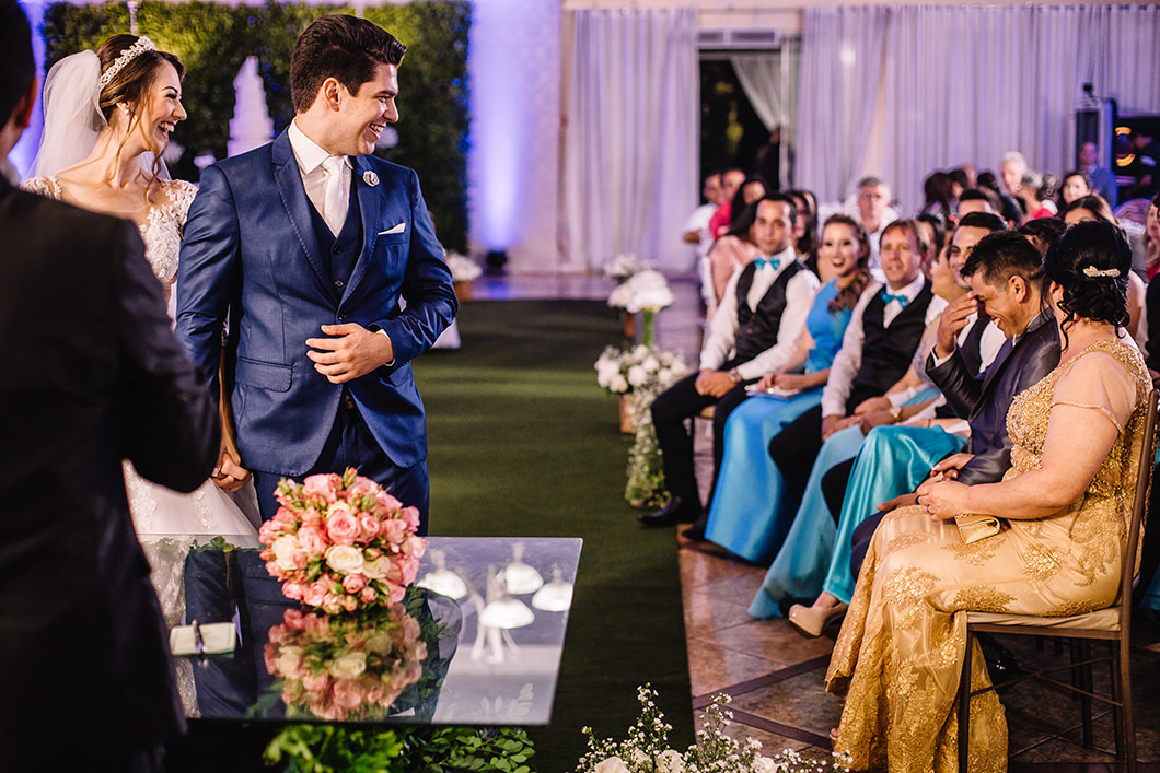 Noivos rindo em cerimonia de Casamento junto com convidados