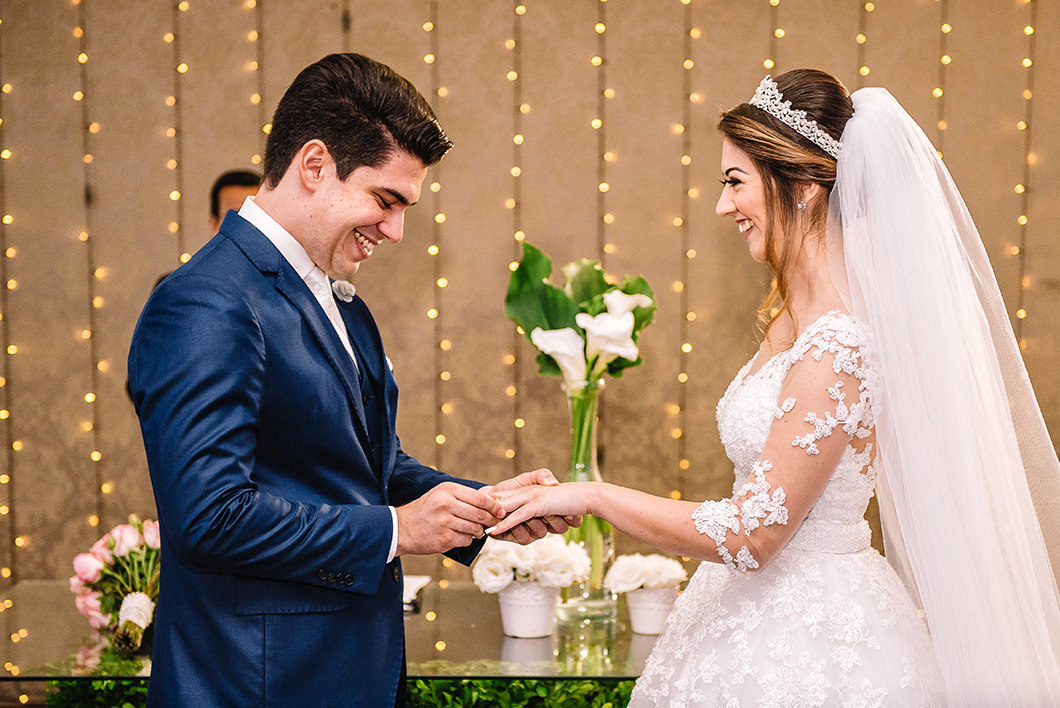 Foto de casamento noivo colocando aliança na noiva 