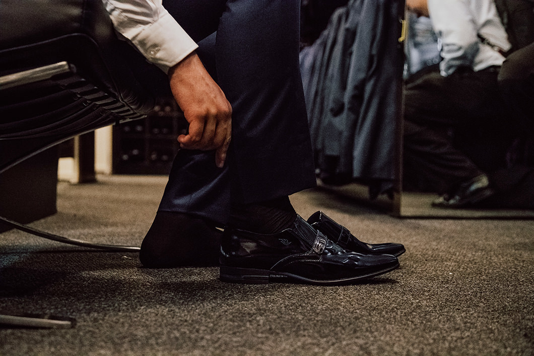 Detalhes do dia do Noivo, fotografia do noivo vestindo sapato de casamento 