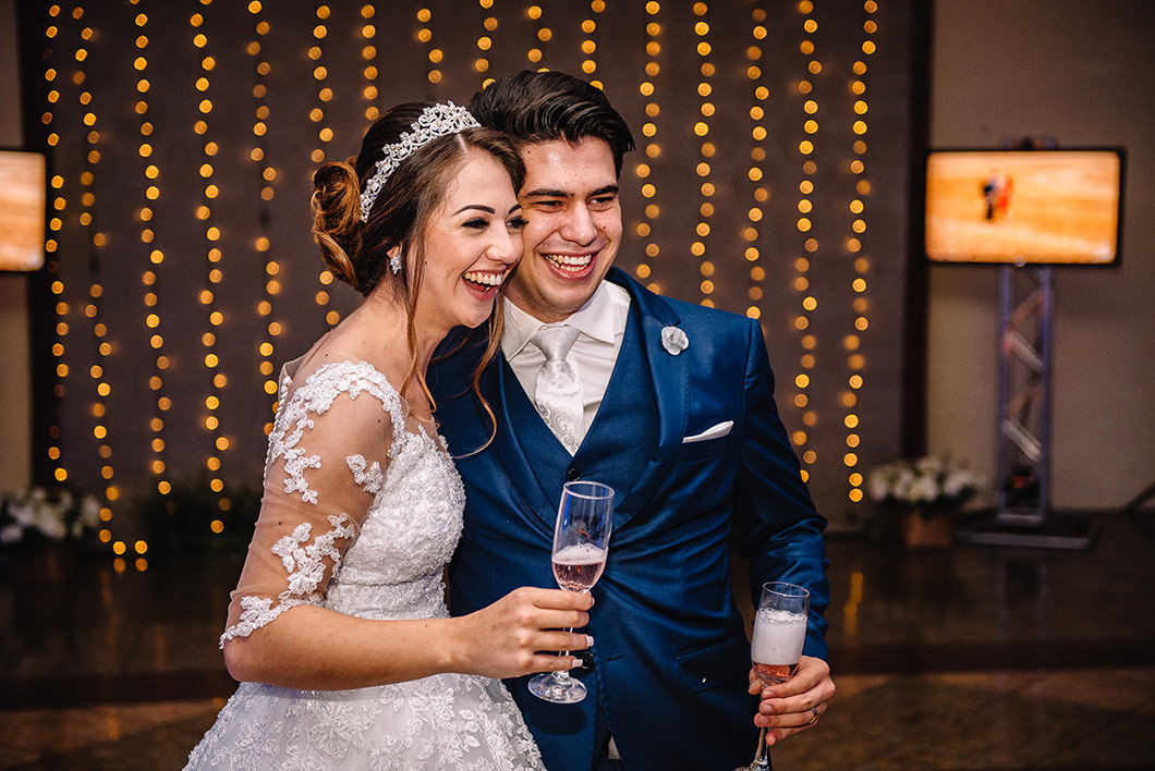 Fotografia espontânea dos noivos na hora do brinde de champanhe