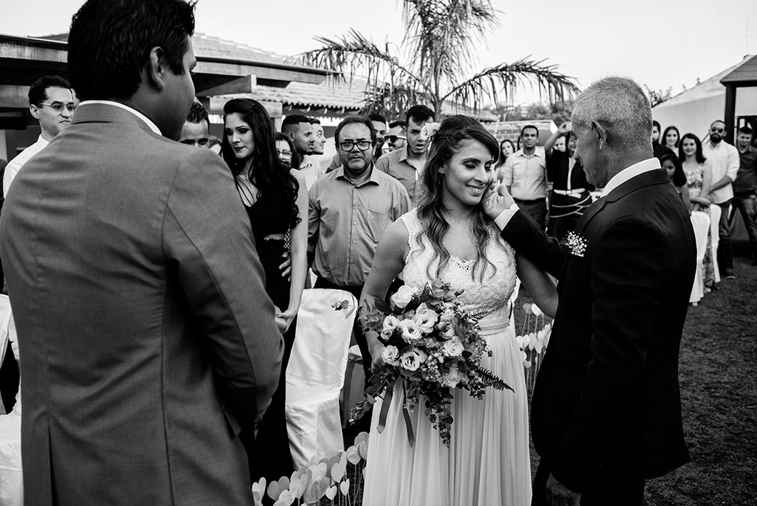 Foto da entrada da noiva com o pai acariciando a filha 