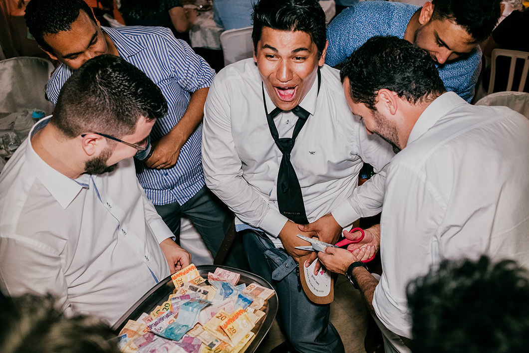 Fotojornalismo em Casamento foto do noivo vendendo a gravata e a cueca
