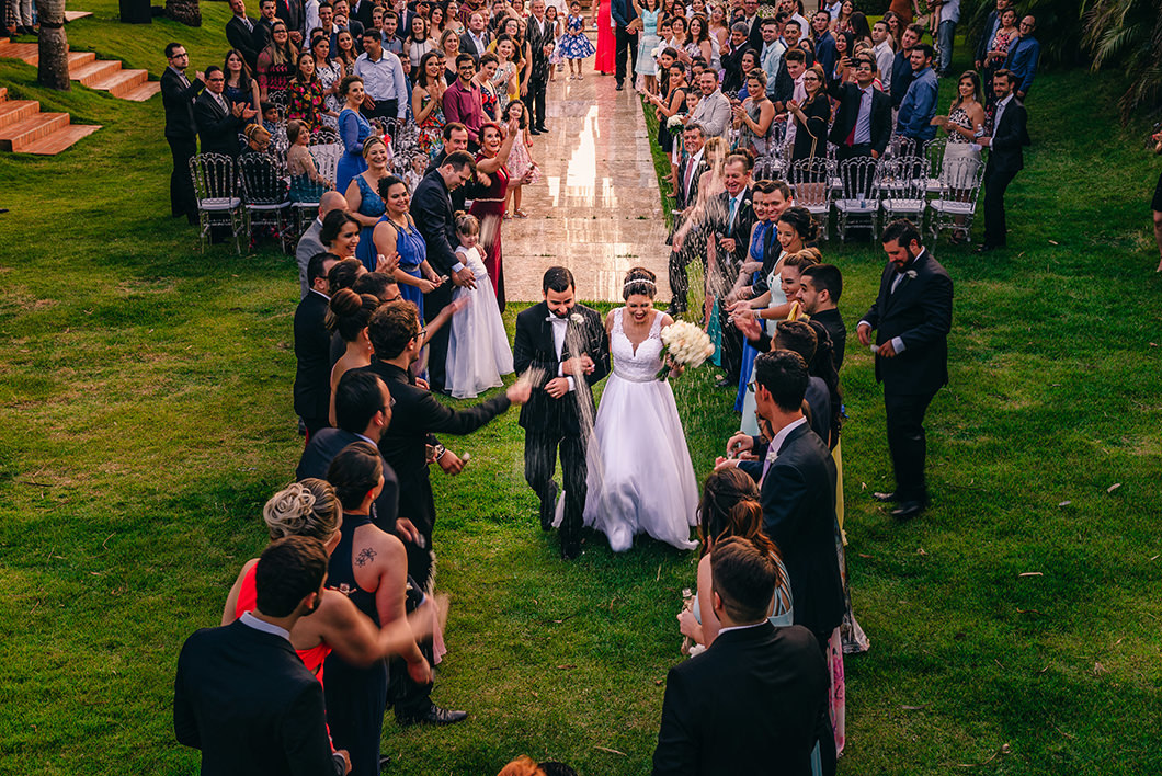 Foto da Saída dos Noivos com chuva de arroz em casamento ao ar livre 