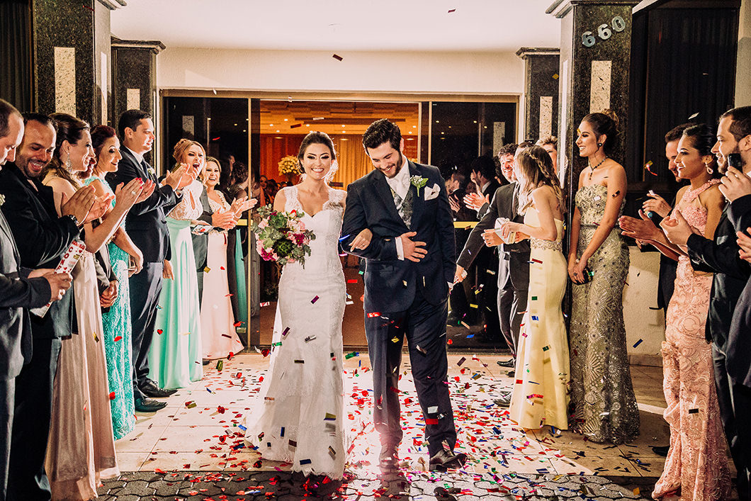 Saída dos noivos do casamento com papeis coloridos 