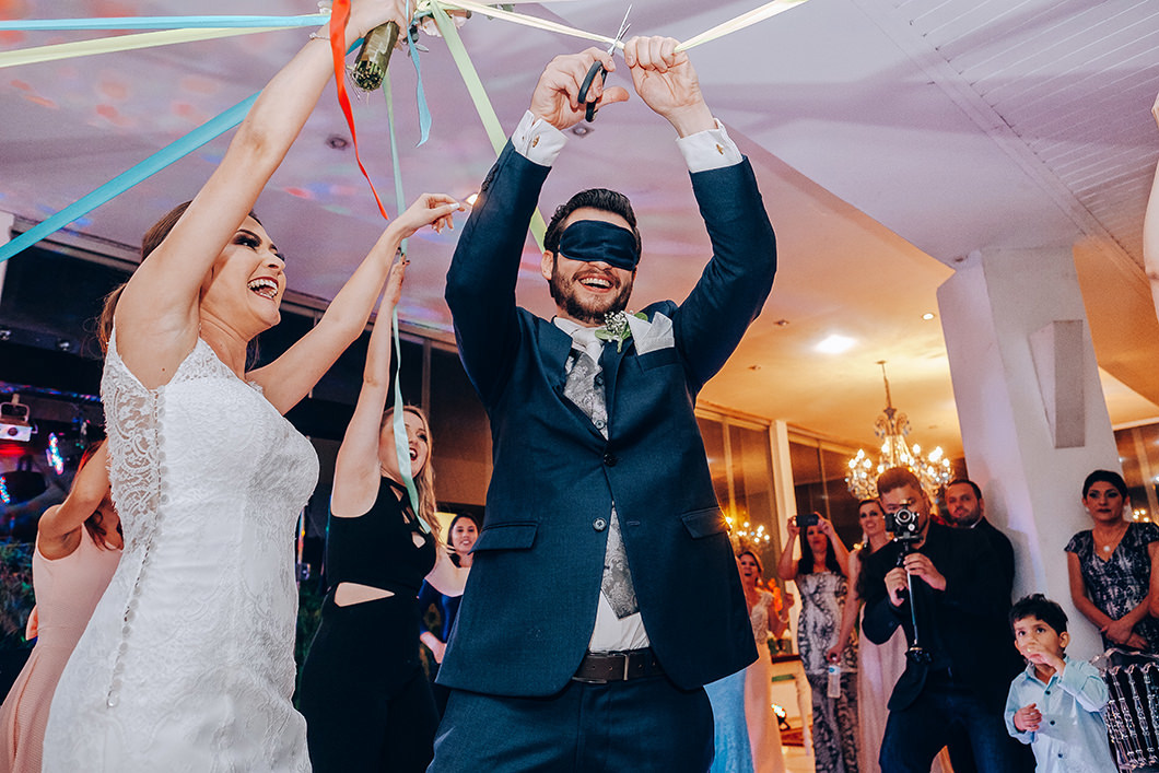 foto do noivo cortando buque de fitas em momento divertido 