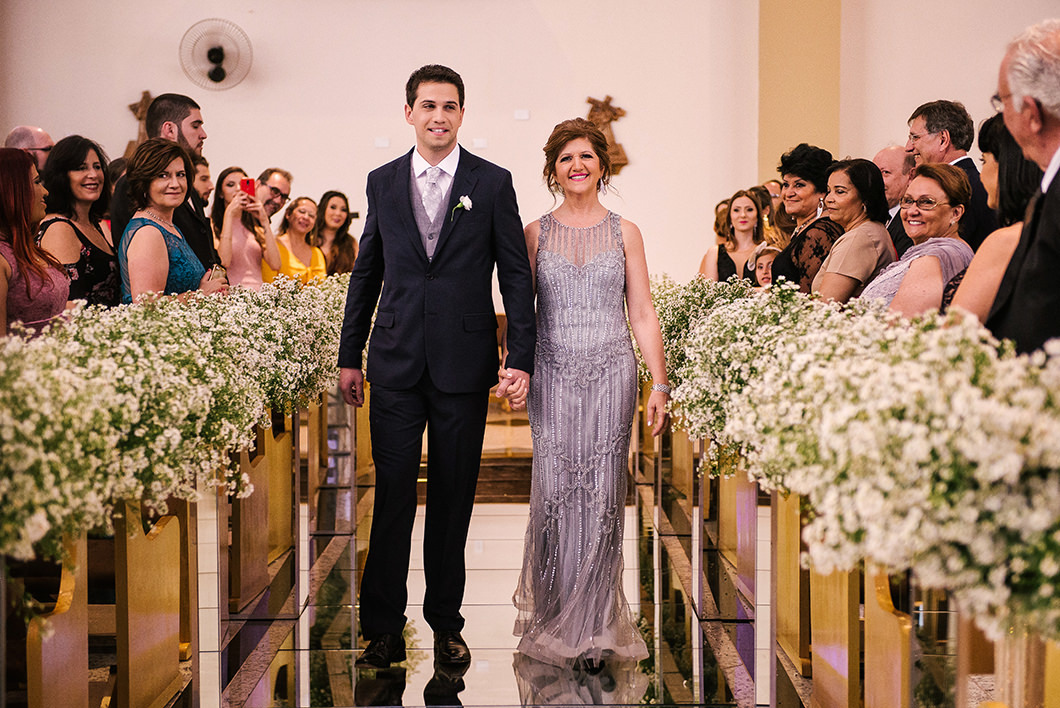 noivo entrando na igreja com a mãe em cerimonia religiosa 