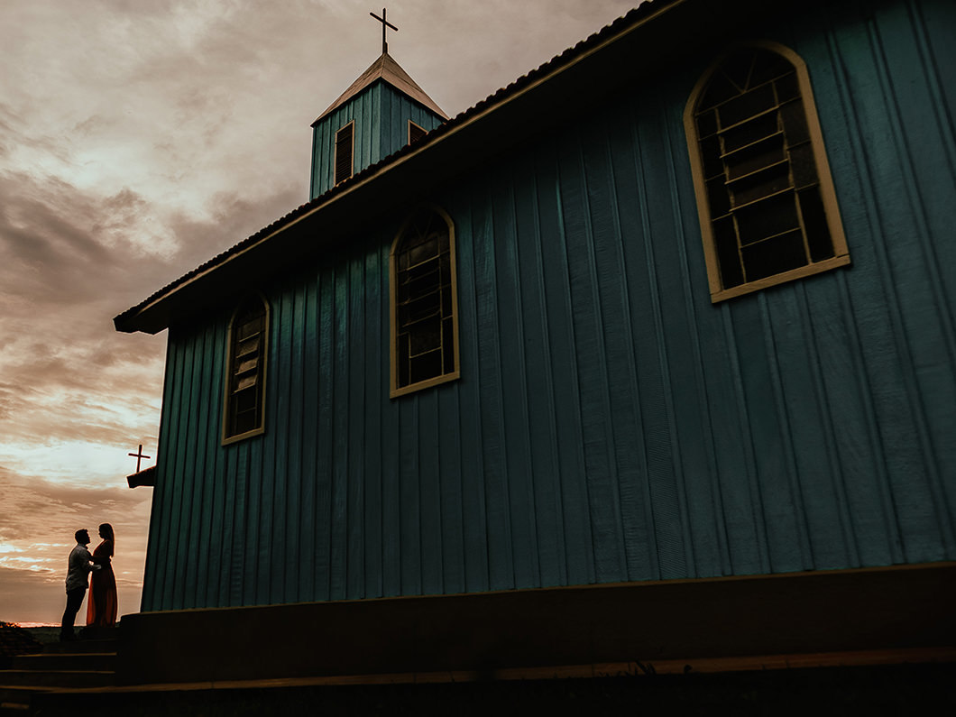 fotografia de casal com por do sol em igreja abandonada 