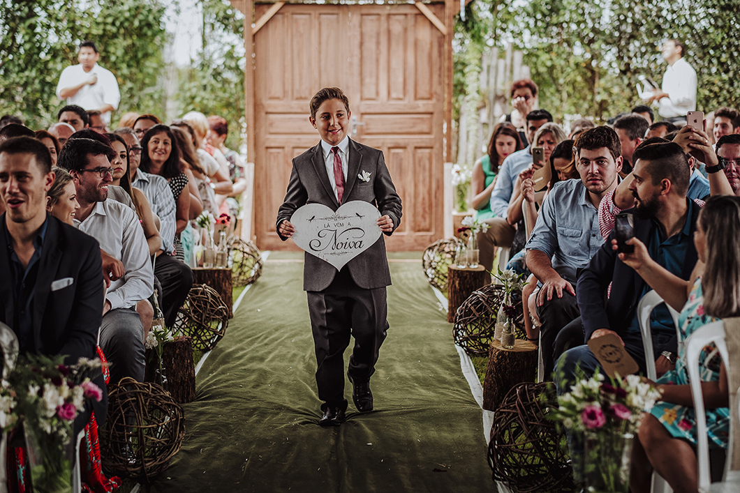 foto da entrada do pajen de casamento plaquinha de madeira avisando entrada da noiva 