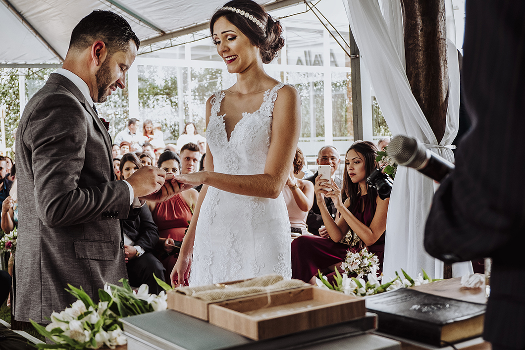 fotos de casamento de dia  com decoração rústica noivos trocando alianças 