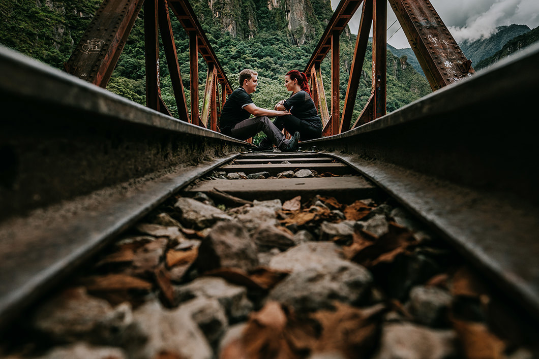 foto linda e diferente de casal em uma linha de trem em passeio na America do Sul
