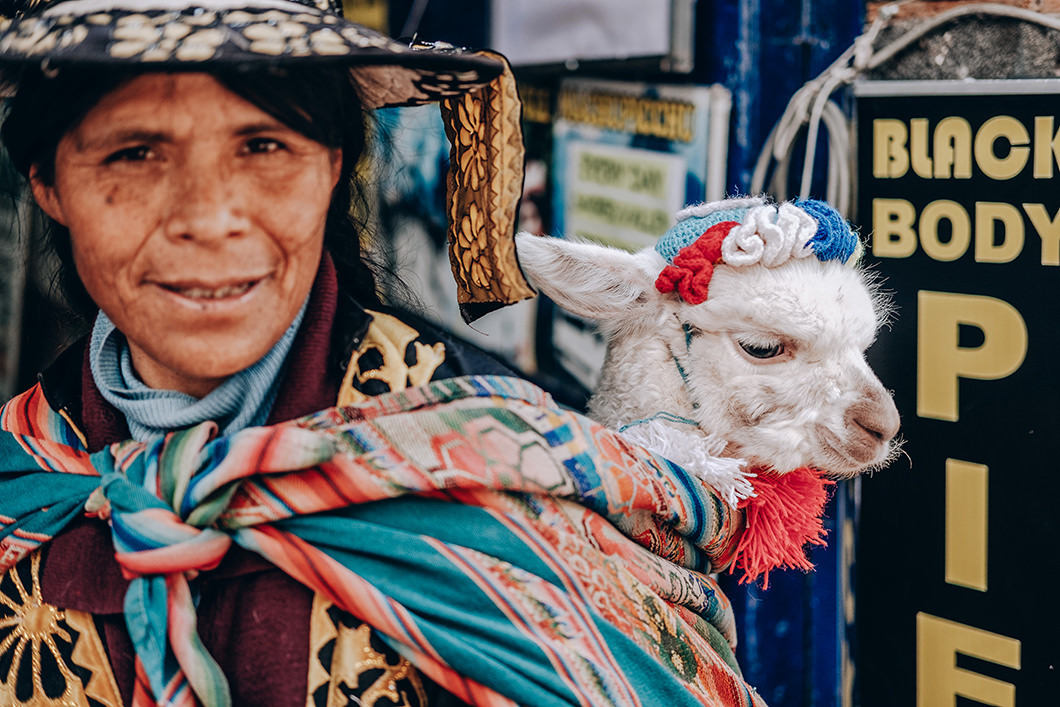 Fotojornalismo de india andando com uma Lhama na cidade de Cuzco-PERU