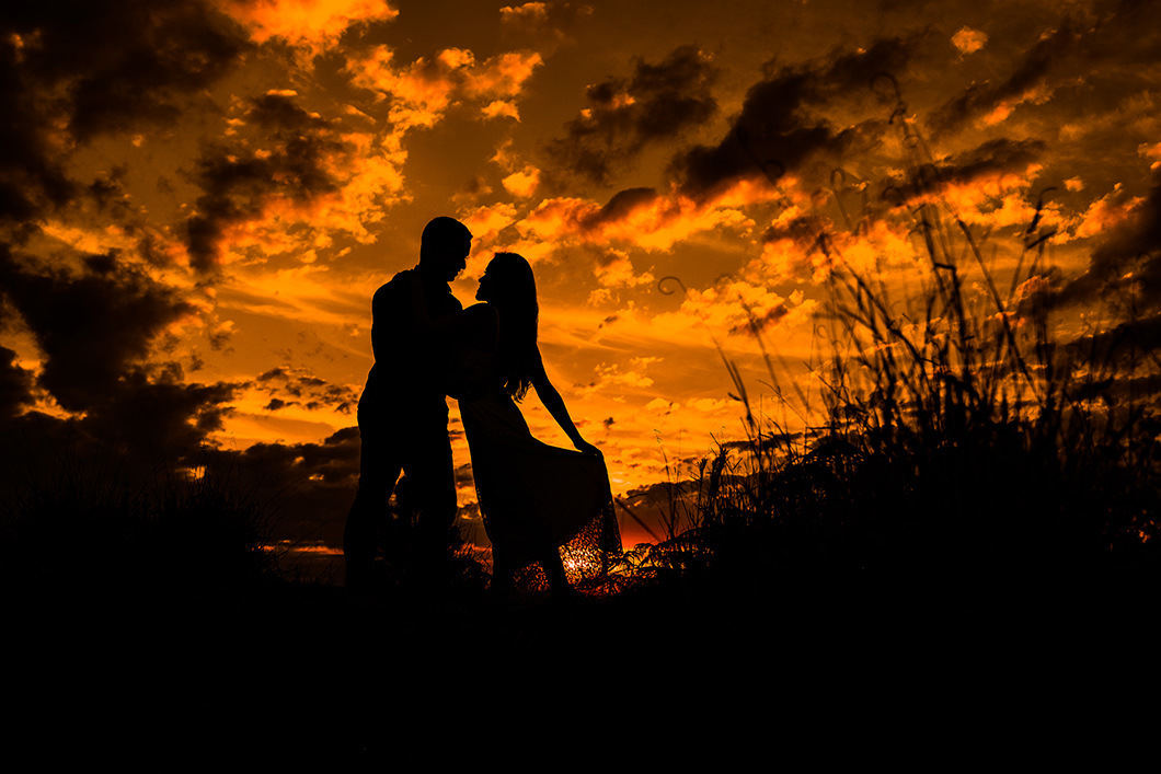 Ensaio pre wedding  do casal no por do sol em cima de uma montanha 