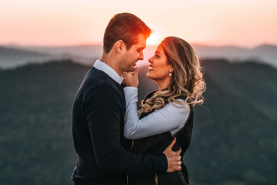 ensaio de casal fotos no amanhecer do sol em cima de um pico 