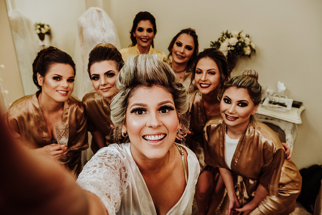 noiva se divertindo em seu making of junto com as madrinhas 