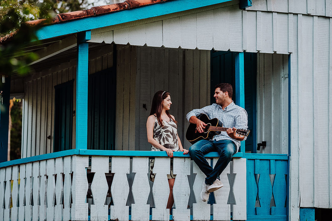 ensaio de casal com fotos divertida do noivo fazendo serenata com violão 