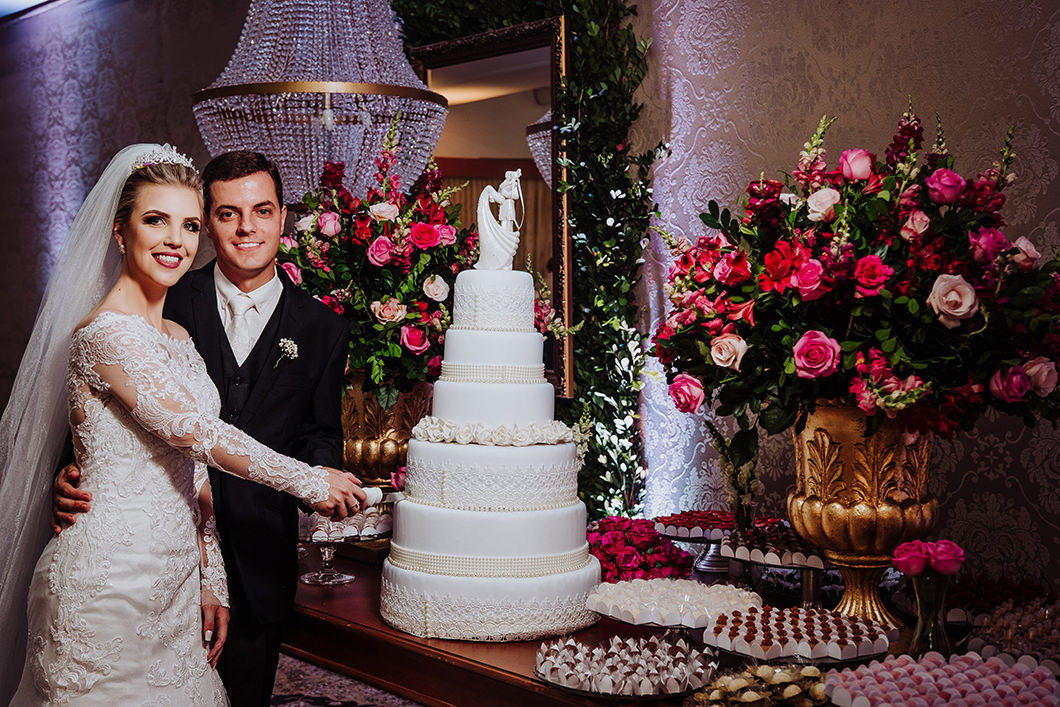 foto tradicional dos noivos cortando o bolo de casamento da mesa de doces rustica 