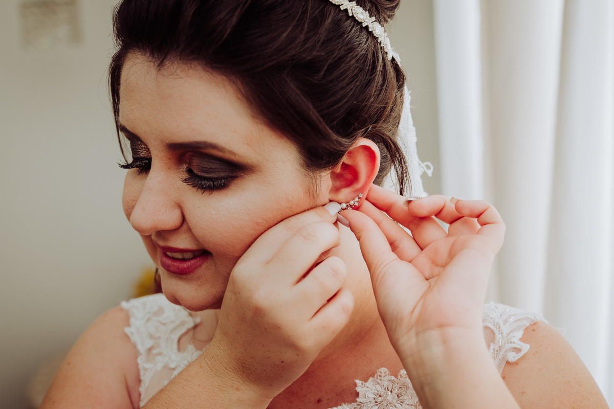noiva colocando brinco de noiva pequeno e delicado 