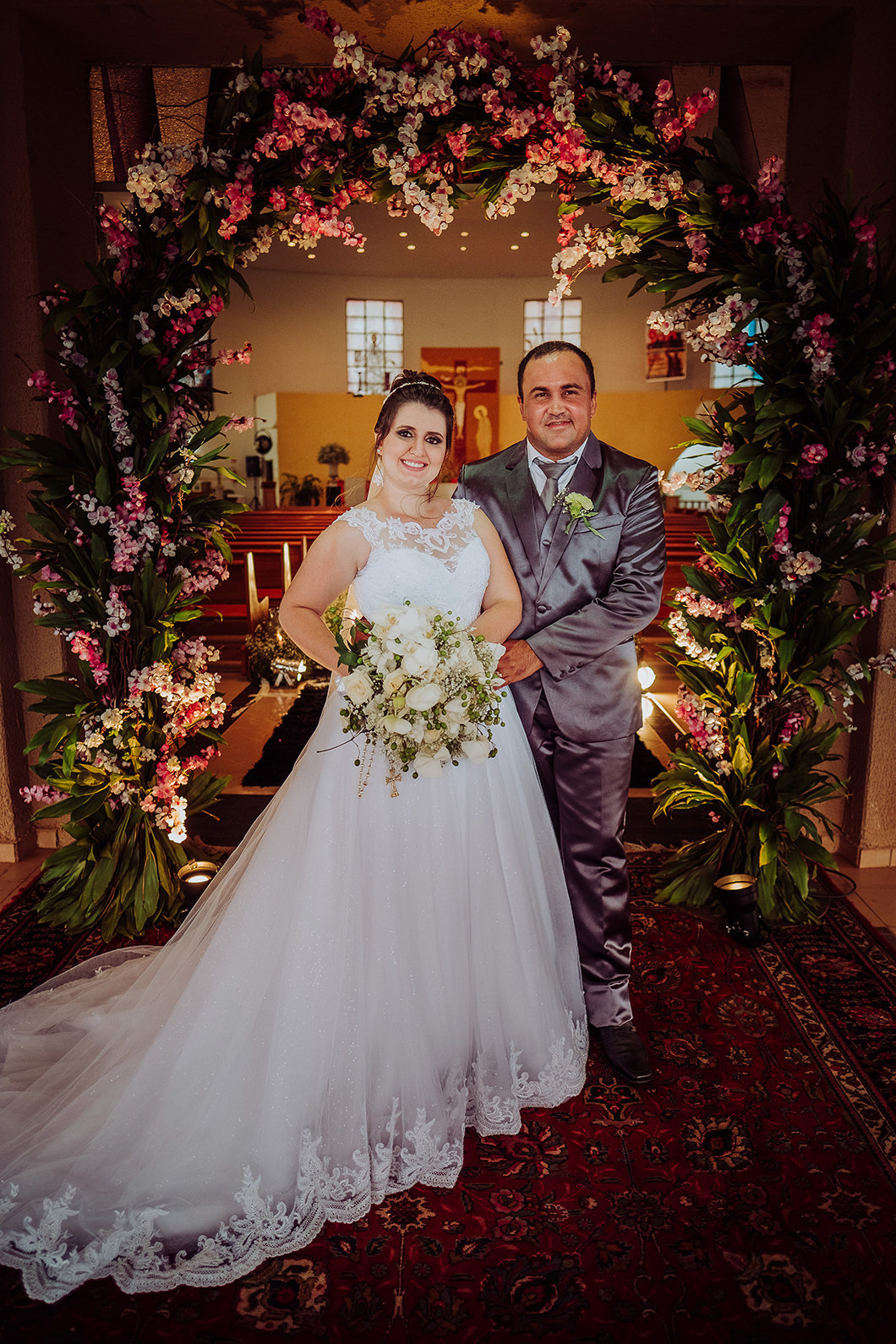 retrato classico dos noivos com decoração da igreja com arco de flores em São Pedro do Ivaí-PR 
