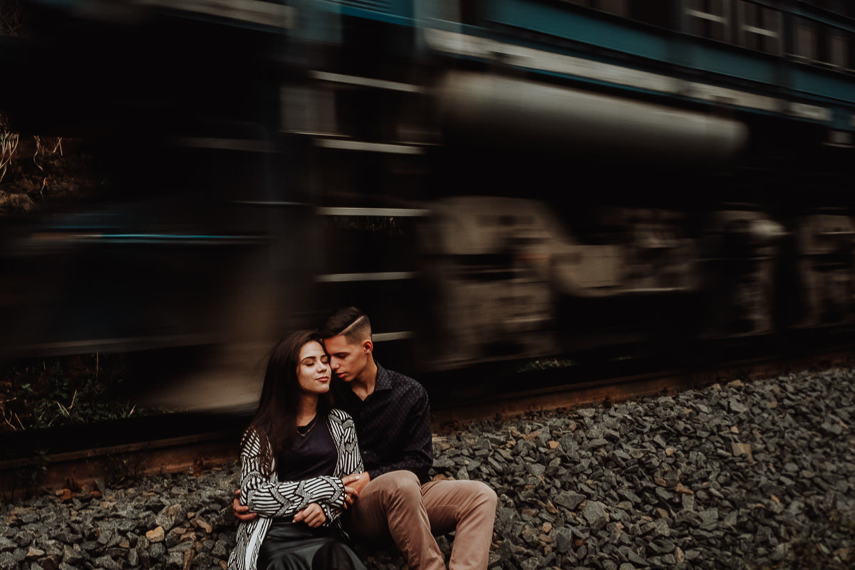 book de pre casamento com fotos incriveis de um casal com o trem em movimento no fundo 