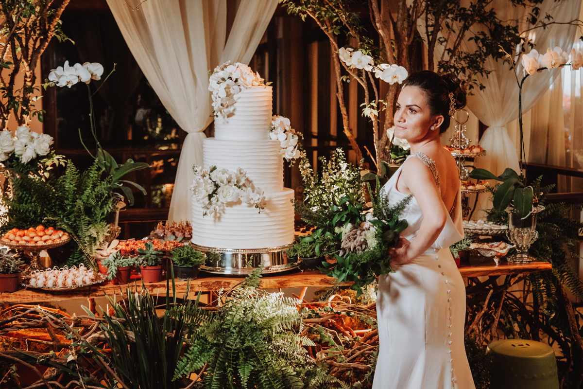 lindos retratos da noiva na mesa de doces rustica com decoração com flores de samambaias e bastante flores verdes 