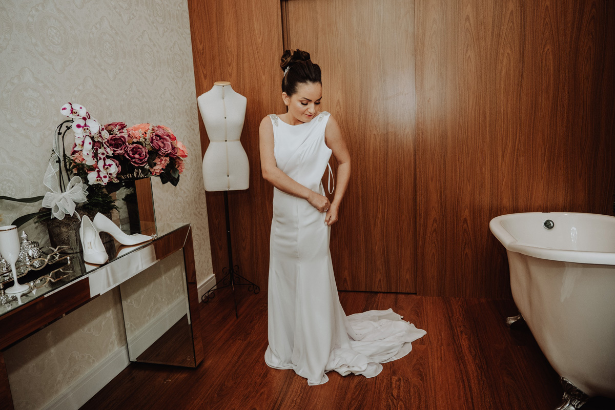 fotos od dia da noiva, noiva colocando o vestido de noiva classico e elegante 