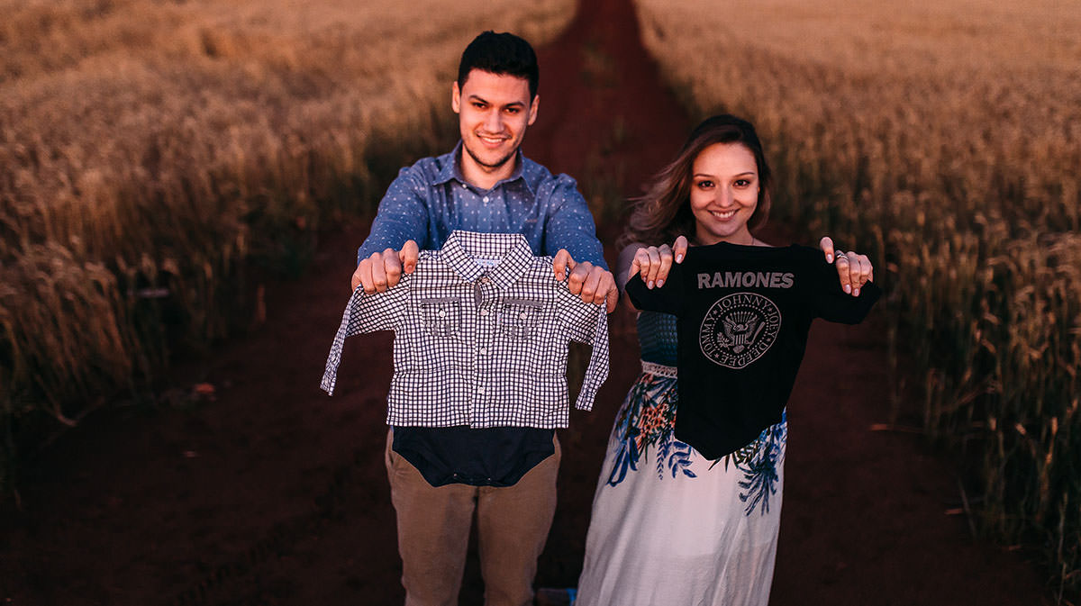 roupinhas de bebe em um book de gestante no trigo