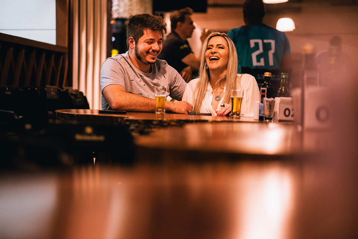 bruno e ludmyla cuintindo as ultimas fotos do pre wedding em um bar