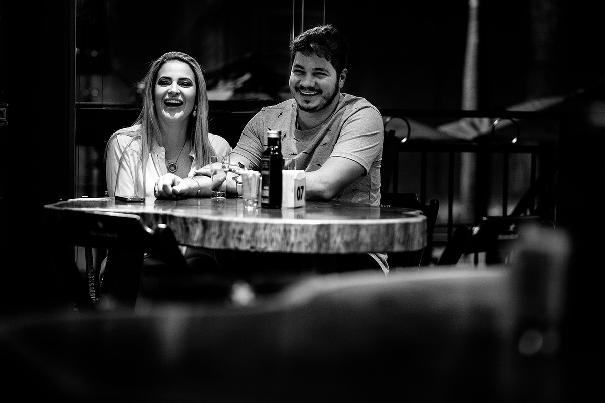 foto preto e branca do casal curtindo o pre casamento no bar