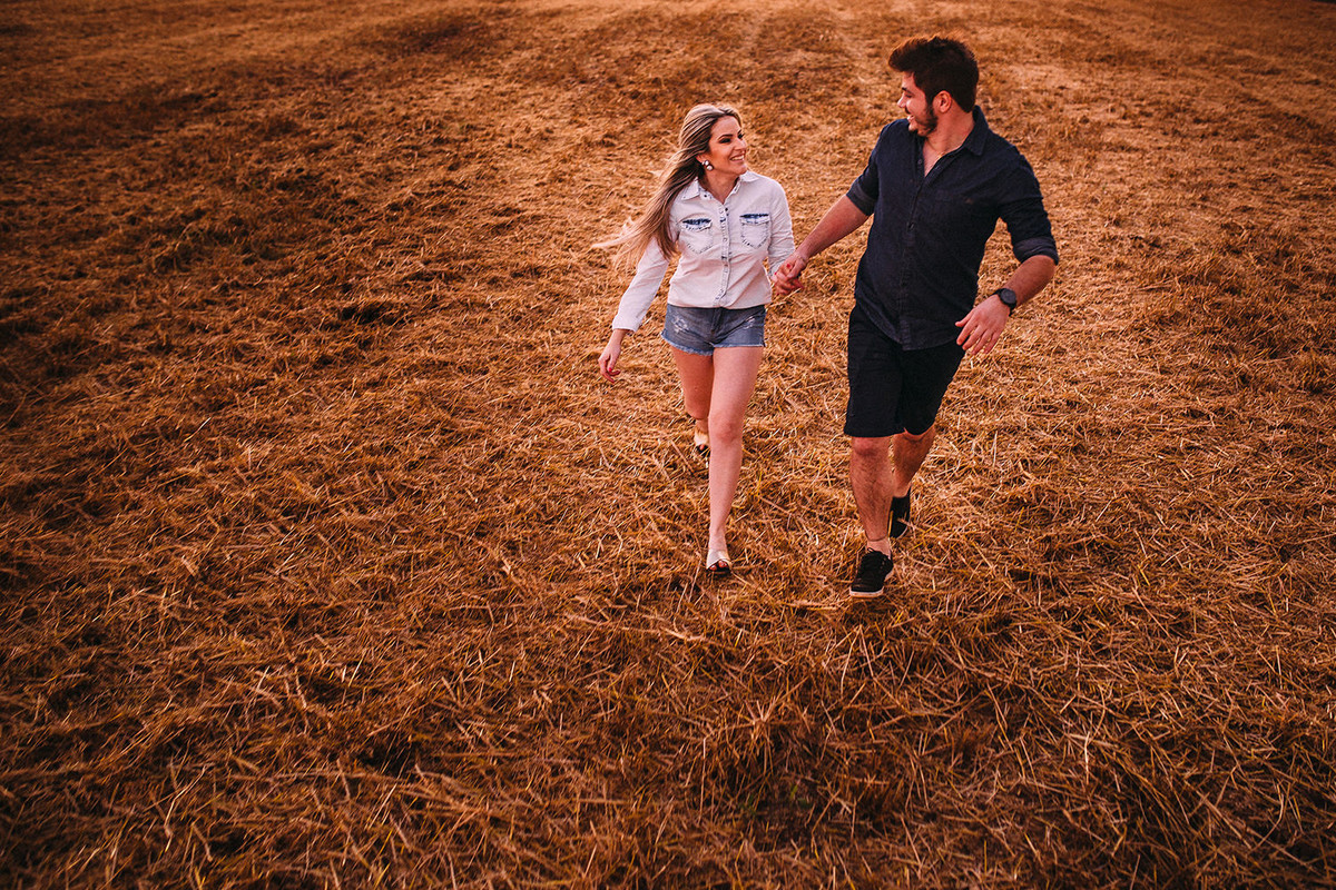 foto do casal correndo no trigo