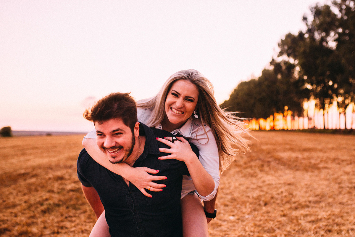noivos sorrindo em uma plantação de trigo