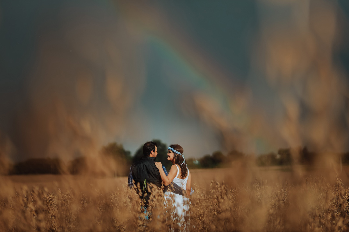 lindo ensaio externo de casal com arco iris como cenario das fotos em ensaio rural 