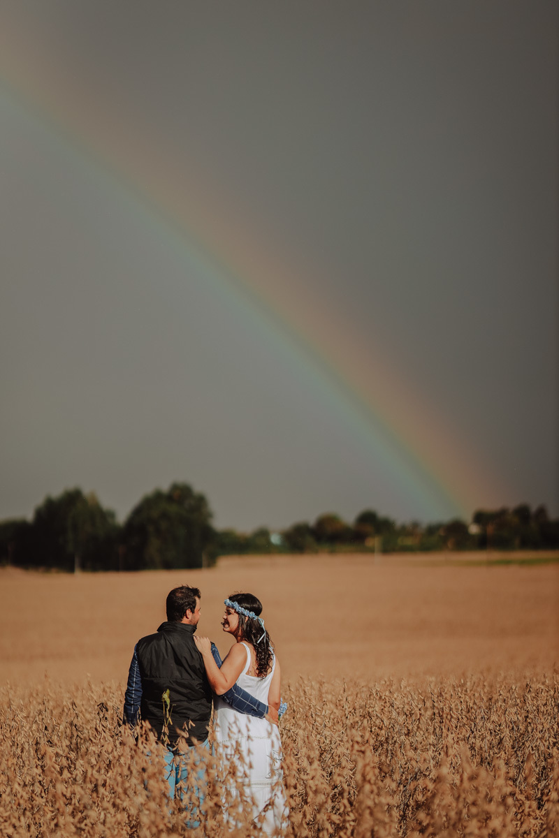 lindo ensaio pre casamento country  com arco iris e plantação de soja 