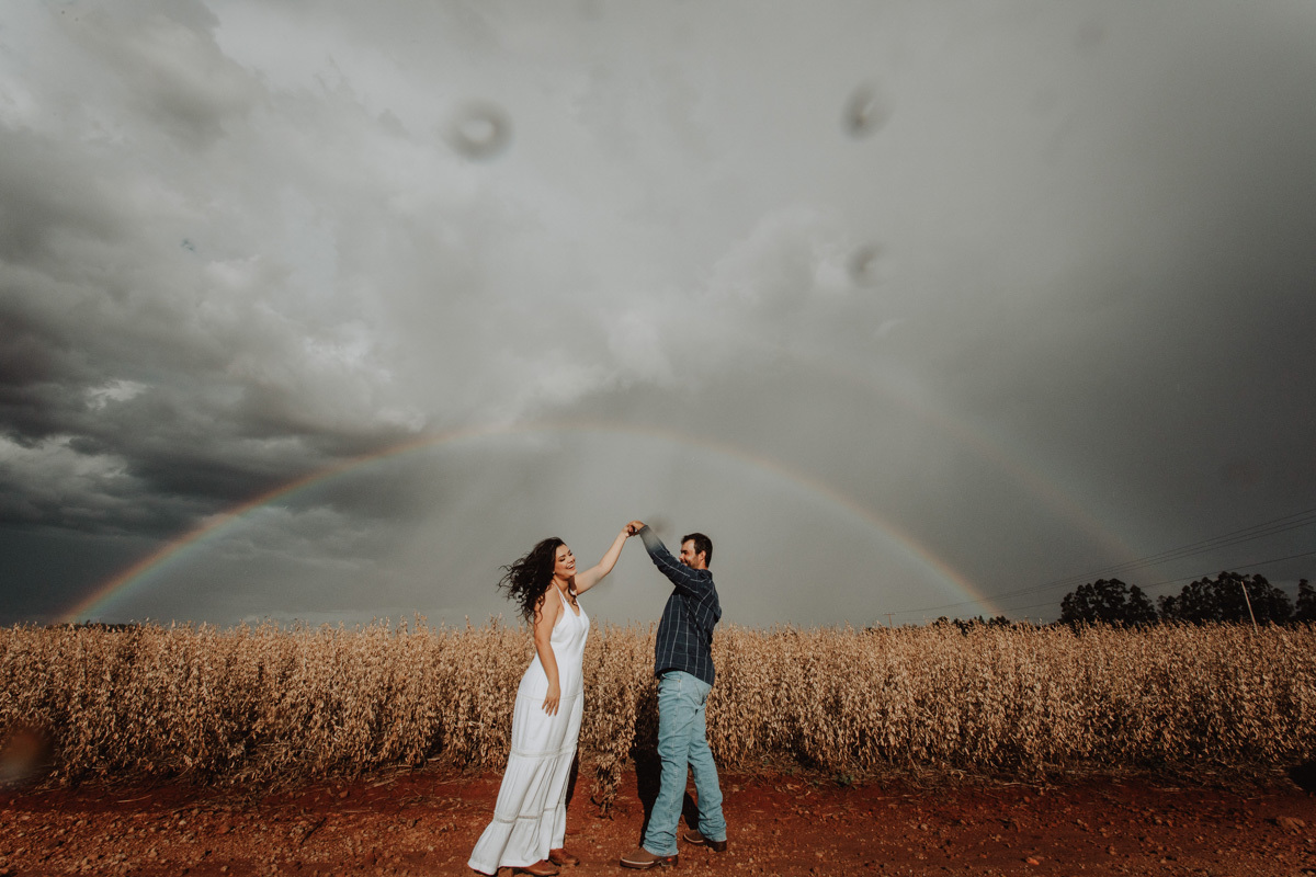 ensaio pre casamento com arco iris no céu fotos em platanção de soja em Pitangueiras-PR 