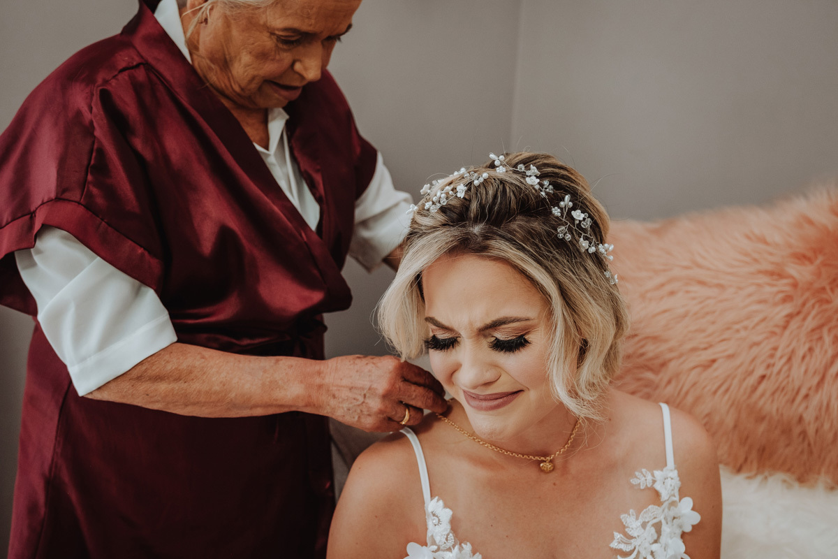noiva com momento emocionante da avó ajudando ela a se vestir 