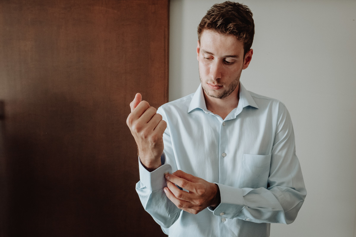 noivo se arrumando em making of do noivo em quarto de hotel 