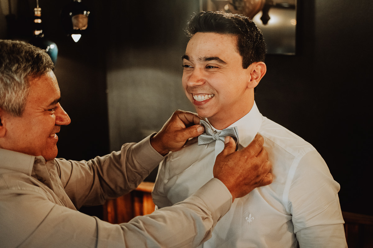 pai do noivo ajudando o filho a se vestir no making of do noivo melhor fotografo de maringa Rickardo Andrade