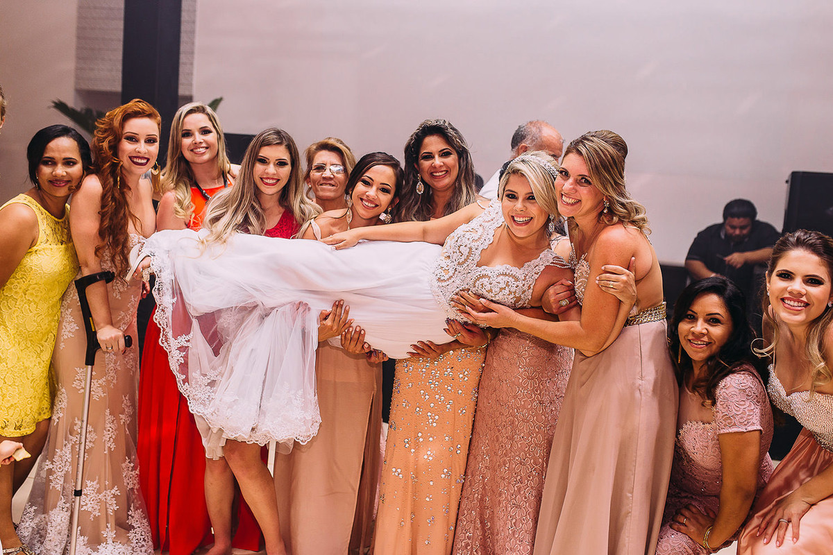 Amigas da noiva levantam ela para foto de casamento