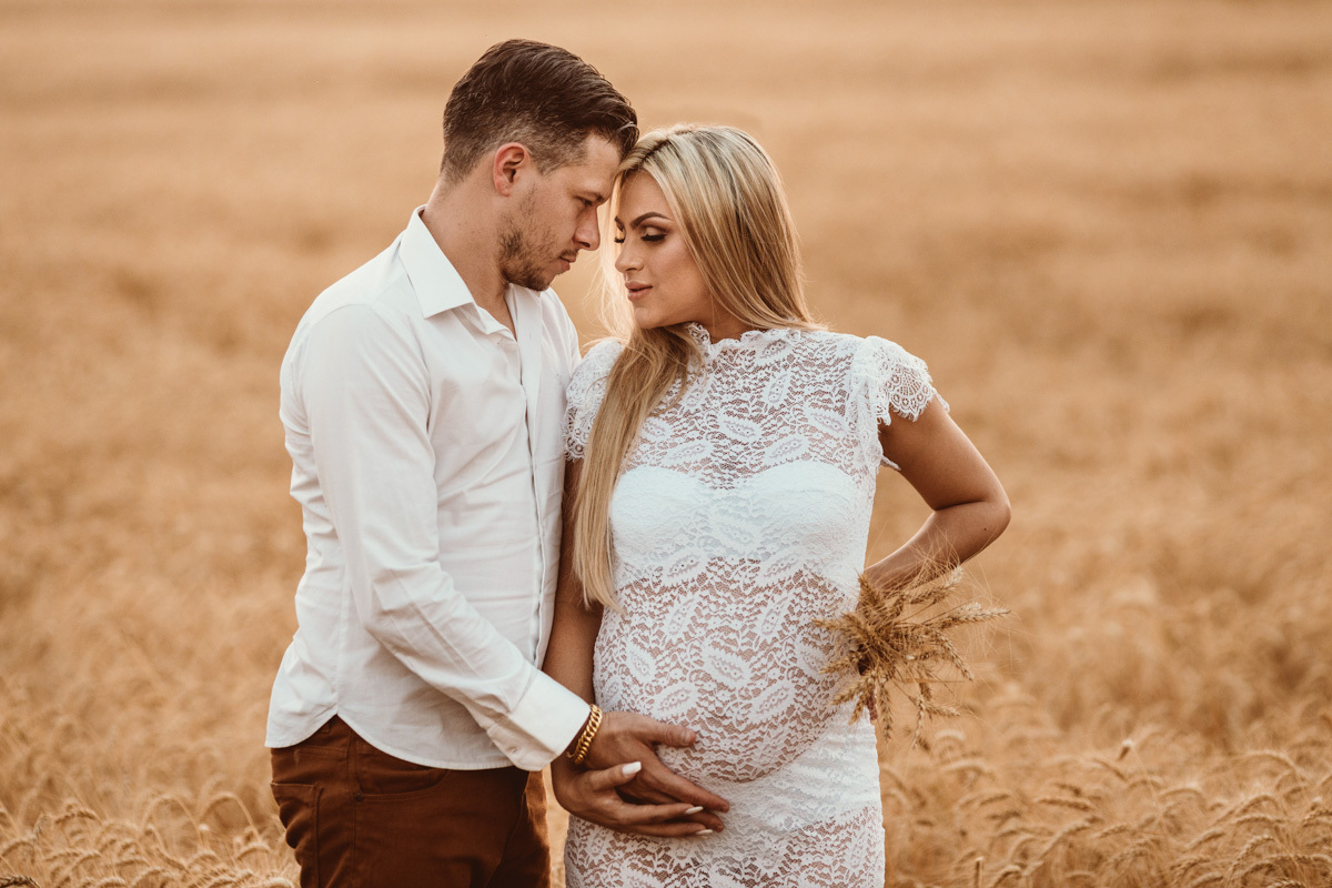 lindo ensaio externo de gestante fotos com o esposo em plantação de trigo douradinha 