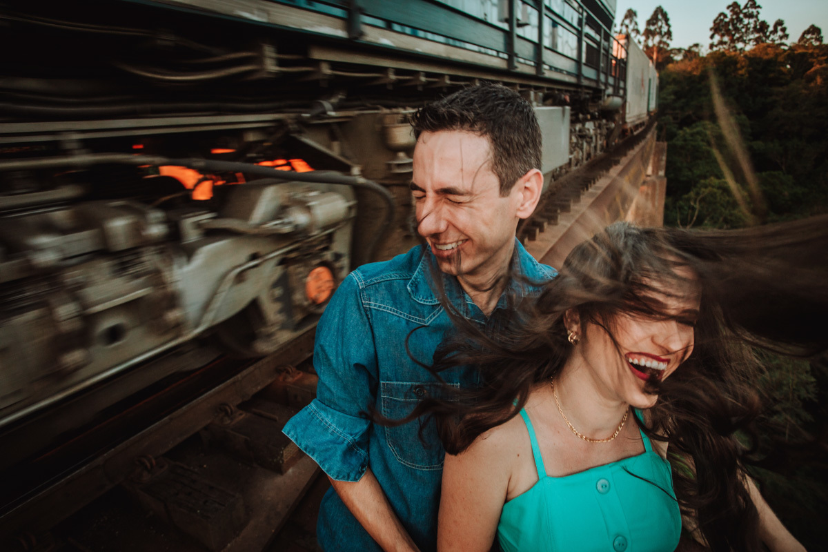 momento divertido no ensaio pre wedding linha de trem suspensa com o trem passando 