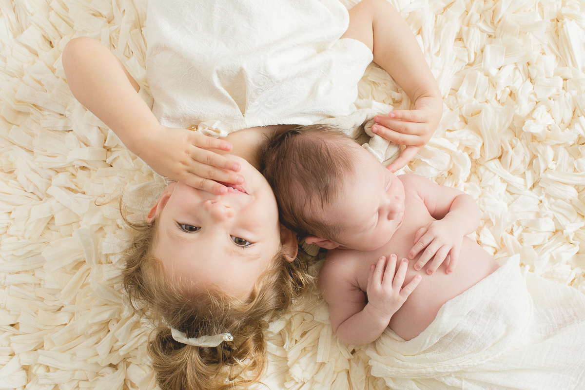 Foto feita na casa do cliente em Curitiba. Book Newborn do Benício com Gustavo Sousa. Tons de bege claro, produção cleam com a irmazinha. Theo deitado no ombro da Cecilia.