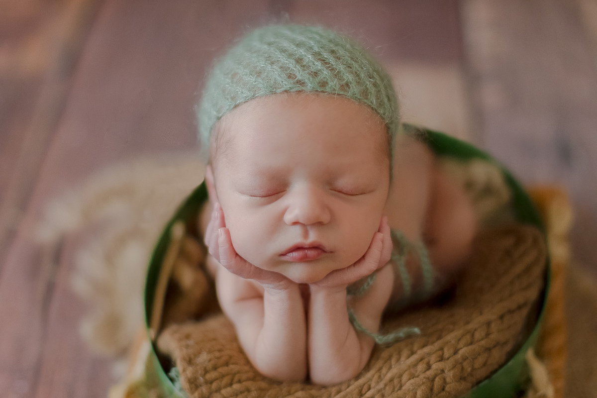  Foto feita no estúdio Gustavo Sousa Newborn em Curitiba. Book do Theo. Sessão de fotos. Pose do sapinho na contra luz com touca verde água. Dentro de baldinho verde. Fundo de madeira