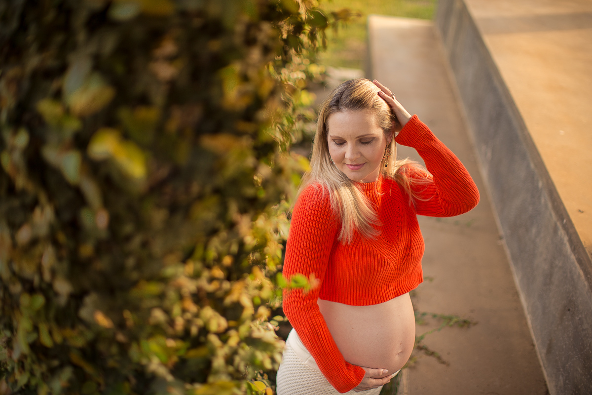 Ensaio gestante da Pamela e Fabio com Gustavo Sousa fotografia em Curitiba. Book em externa em haras. Gravida com calça amarela e blusa laranjada. Pose na escada 