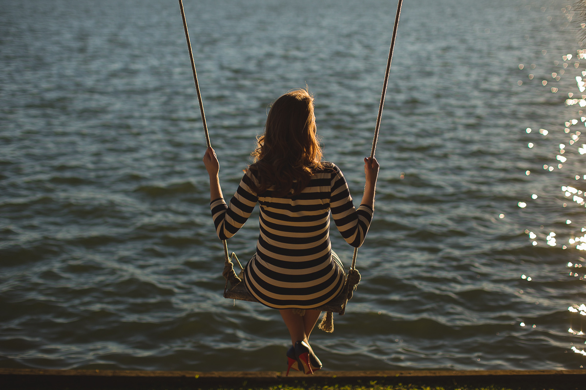 Ensaio gestante da Viviane e Adilson no estúdio Gustavo Sousa fotografia em Curitiba. Book em externa. Vestido listrado. Local Laggus Residencial Náutico . Gustavo Sousa Fotografia.  Ensaio Gestante. Balanço na represa Passaúna.