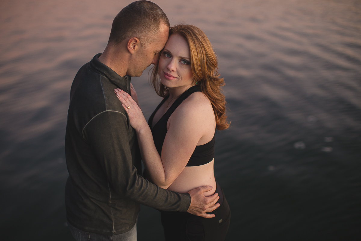 Ensaio gestante da Viviane e Adilson no estúdio Gustavo Sousa fotografia em Curitiba. Book em externa. Local Laggus Residencial Náutico . Gustavo Sousa Fotografia.  Ensaio Gestante.  Mãos na barriga. Roupa verde e preta. Abraçados no lado com por do sol