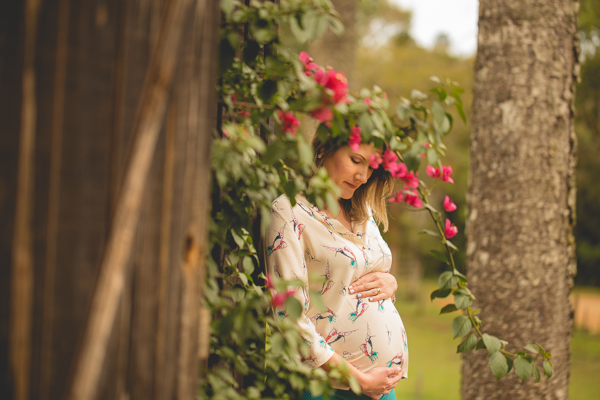 Ensaio Gestante em Curitiba. Book da Naira e Leandro com Gustavo Sousa e Kátia Hille. Locação rústica com cavalos e cachorros. Gestante com sorriso espontâneo. Camisa Bege e calça verde. Flores 